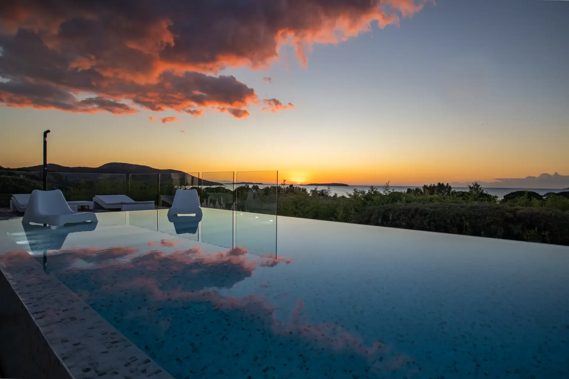 Piscine &agrave; d&eacute;bordement au coucher de soleil, vue mer Cerbicales