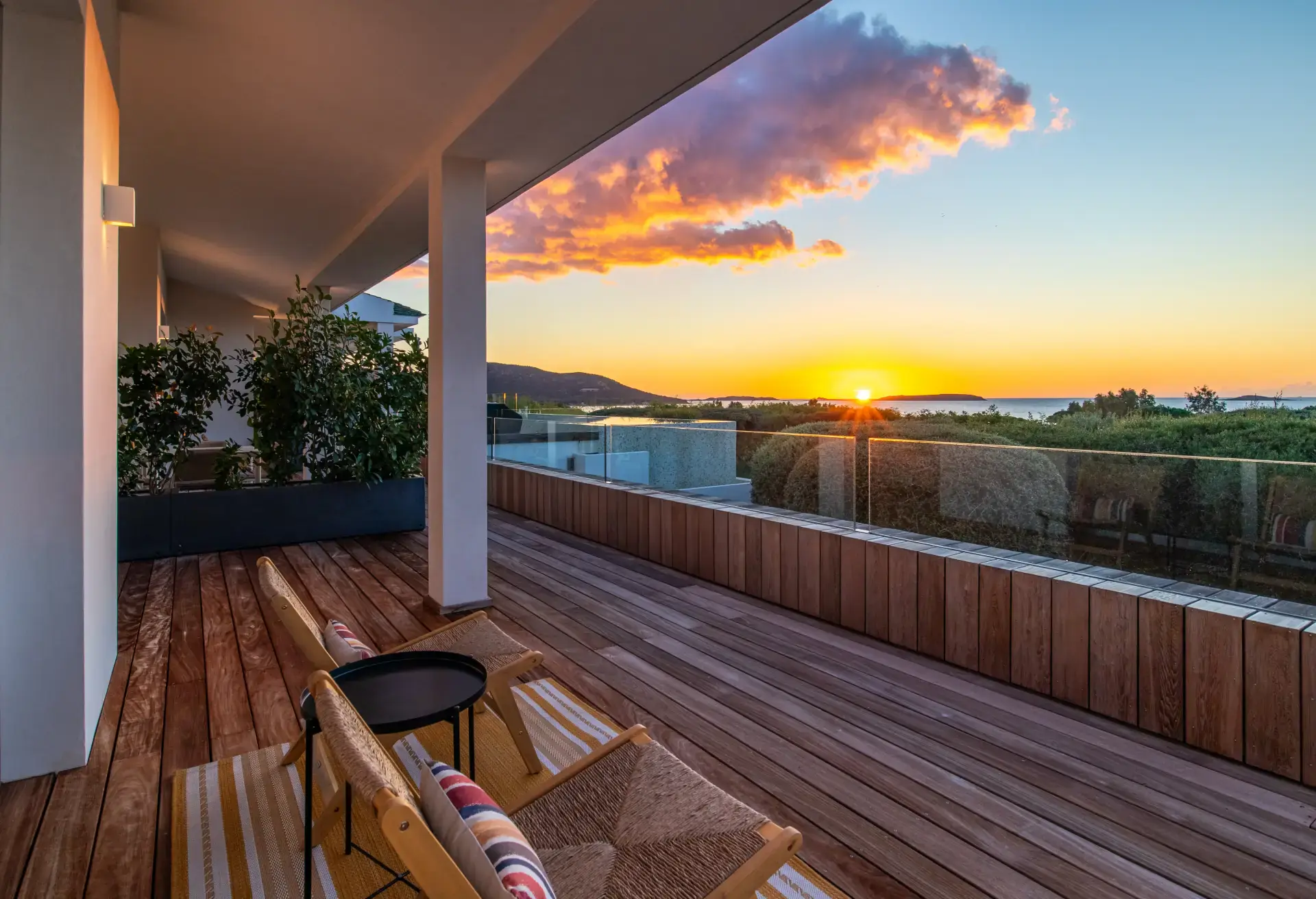 Terrasse en bois au coucher de soleil avec vue sur la baie